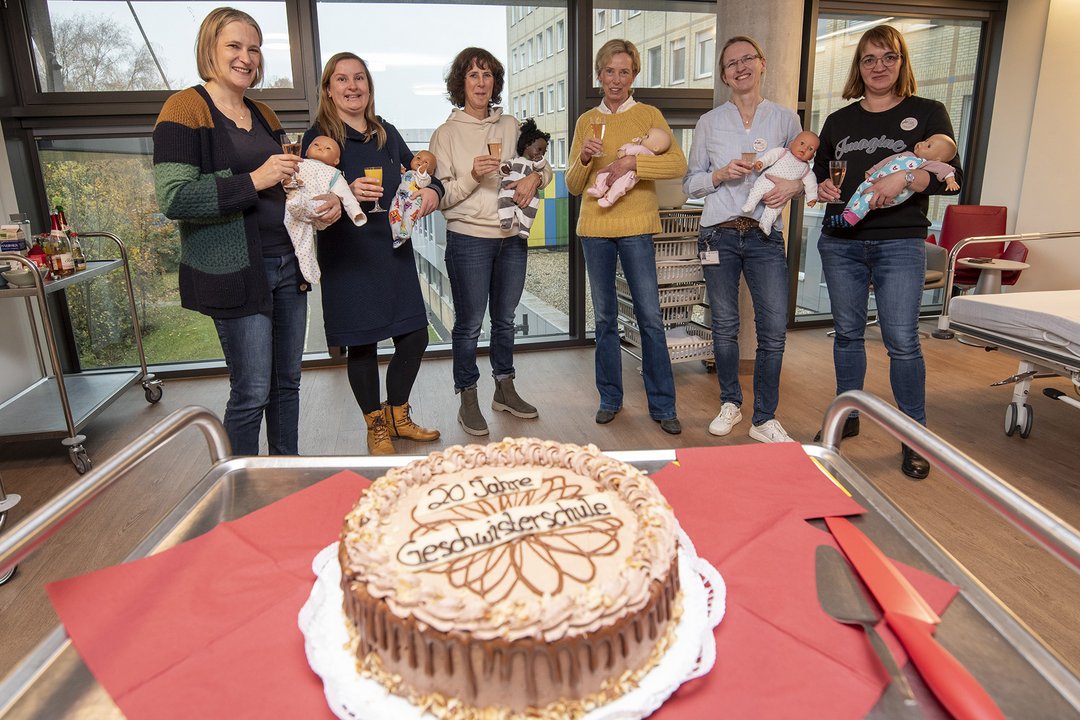 Mehrere Personen stehen um eine Torte herum