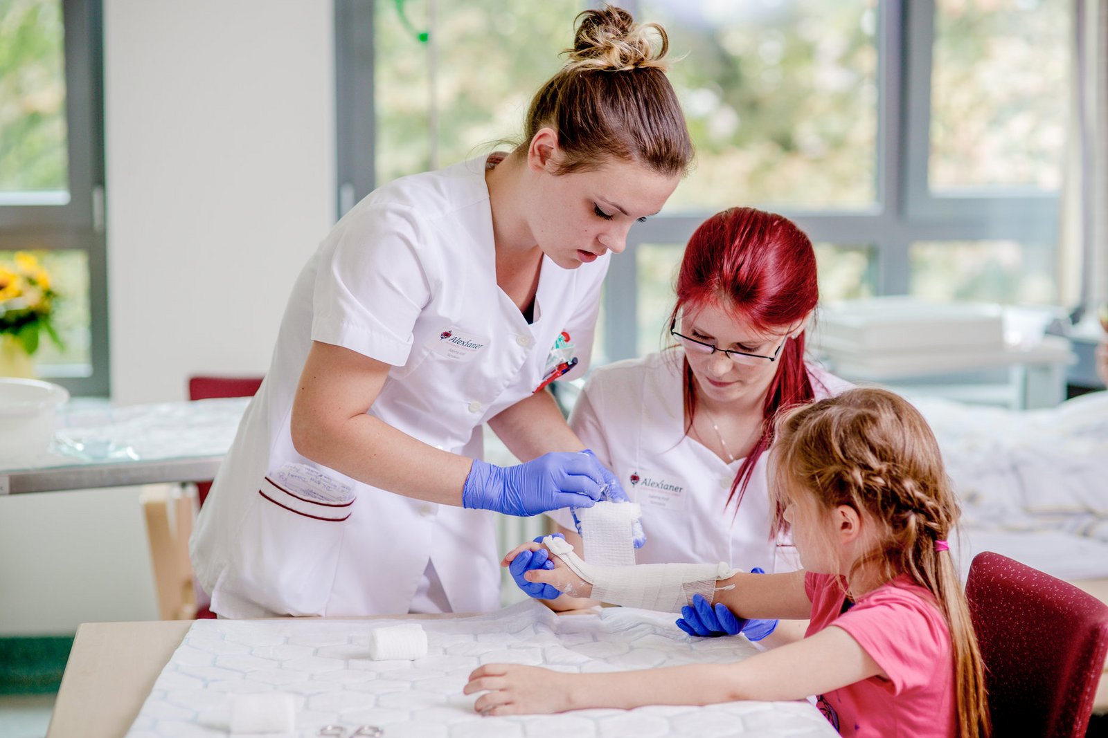 Pflegerinnen wechseln einen Verband