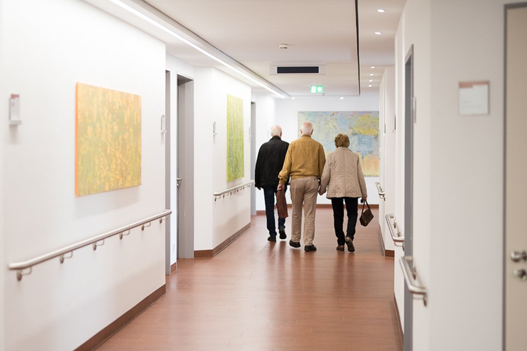 Mehrere Besucher gehen über einen Flur