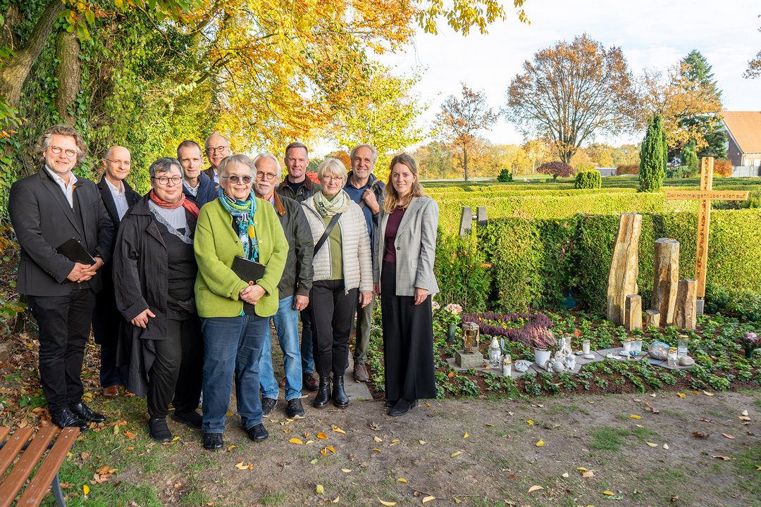 Mehrere Personen stehen an der Grabstelle der "Sternenkinder"