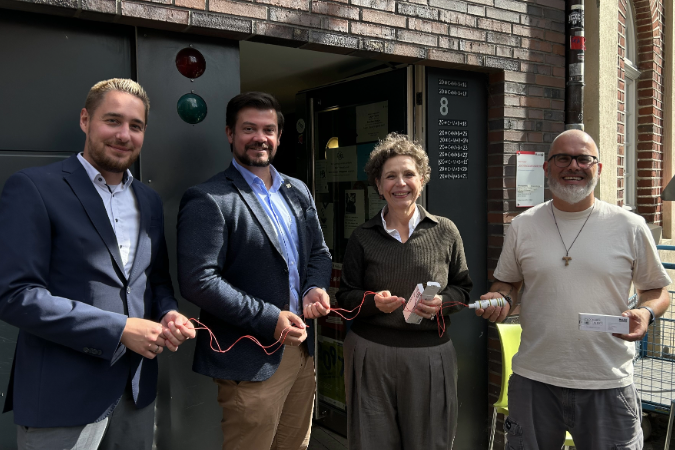 Vier Personen stehen zusammen. Zwei Entwickler übergeben zwei Exemplare der Alarmanlage „Clochard Alert“ an zwei Mitarbeitende der Alexianer Münster GmbH am Treffpunkt „An der Clemenskirche“. Das Gerät wurde im Rahmen eines Studierendenprojekts an der Ruhr-Uni Bochum zur Unterstützung von Obdachlosen entwickelt.
