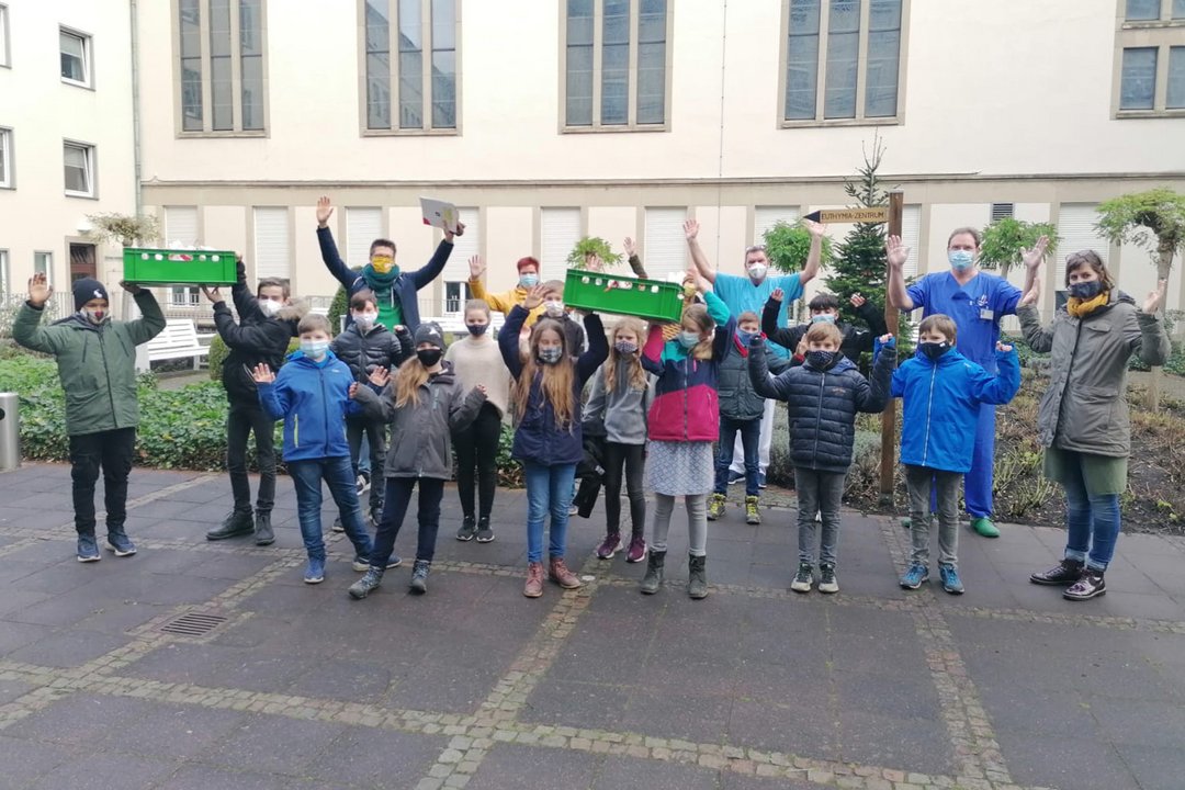 Viele Kinder präsentieren Kisten mit Keksen