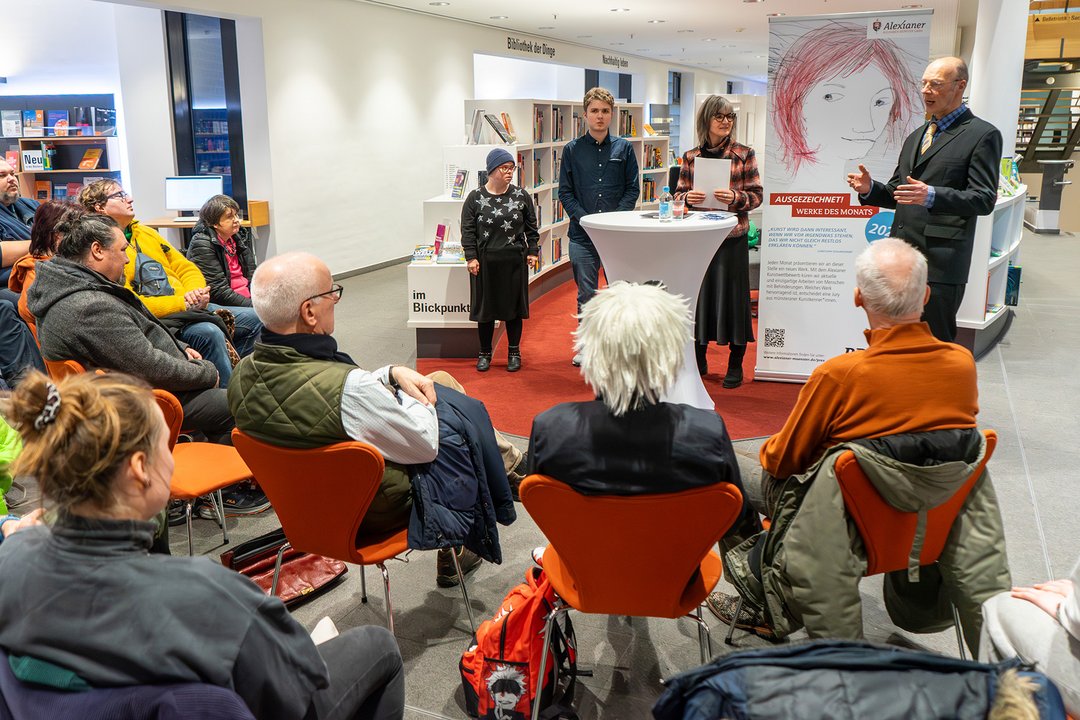 Das Publikum hört drei Künstlerinnen und Künstlern zu