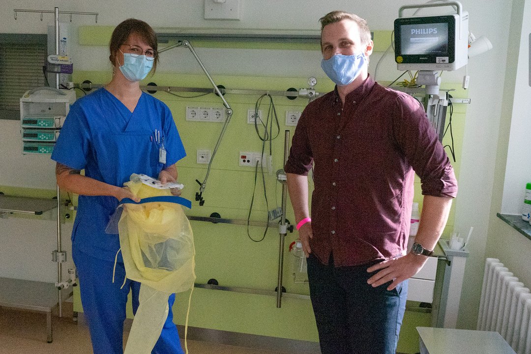 Ein Patient und eine Pflegekraft stehen in einem Patientenzimmer