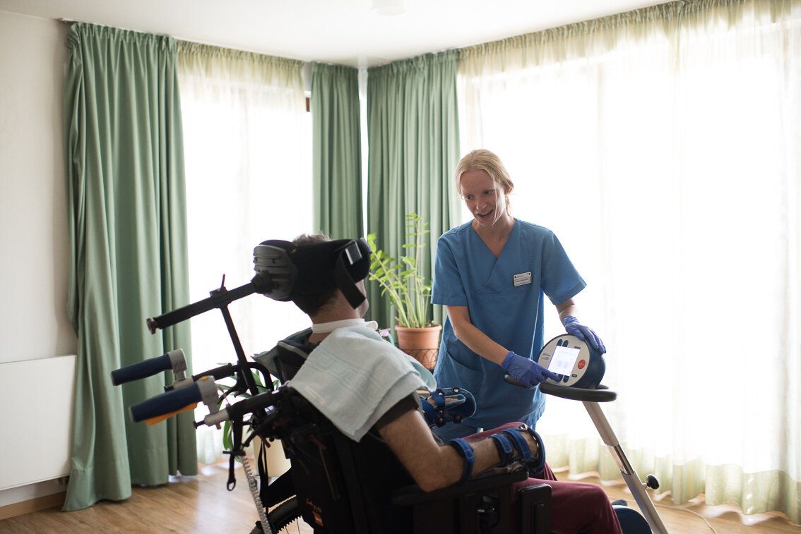 Bewegungstherapie für einen Patienten im Rollstuhl 