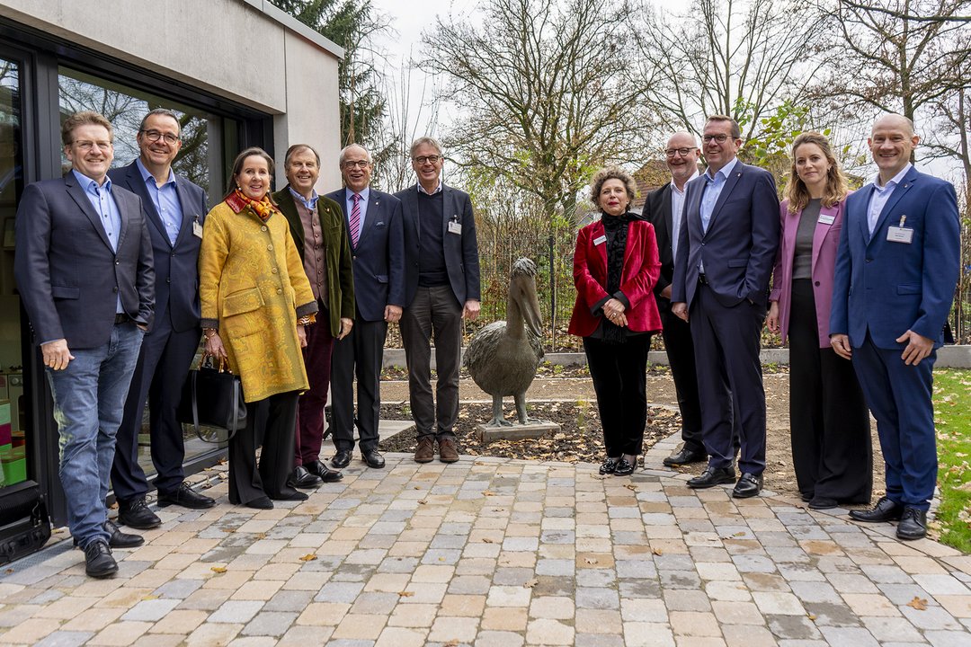 Mehrere Personen stehen um eine Pelikanhaus-Skulptur herum