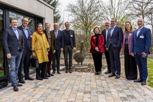 Mehrere Personen stehen um eine Pelikanhaus-Skulptur herum